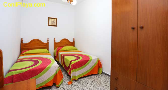 Dormitorio con dos camas individuales y terraza.